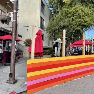 Outdoor tables in this colorful sidewalk parking cutout