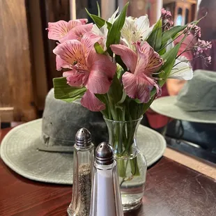 a vase of flowers and salt and pepper shakers