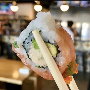 a close up of a sushi with chopsticks