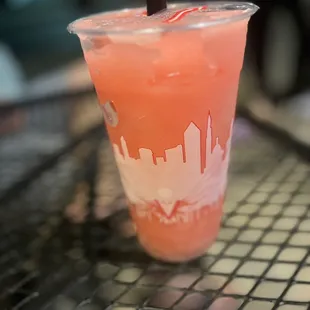a pink drink in a plastic cup