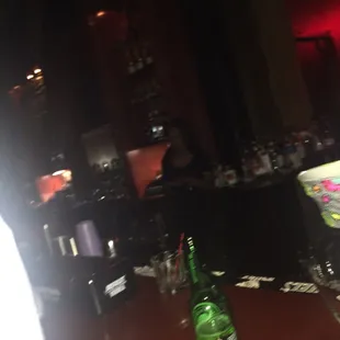 a woman sitting at a bar with a bottle of wine in front of her