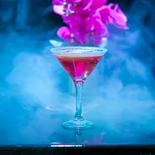 a pink cocktail with smoke in the background