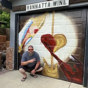 a man kneeling in front of a mural