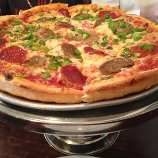 a boy sitting in front of a pizza
