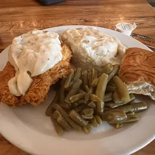 Chicken fried chicken, mashed potatoes, green beans, and a roll.