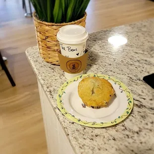 a cup of coffee and a muffin on a plate