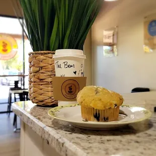 a cup of coffee and a muffin on a plate
