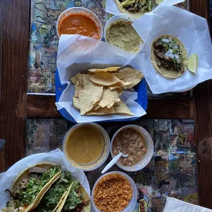 Al pastor and bistek tacos, chips and salsa, rice and beans.