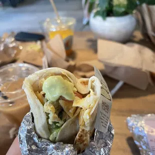 a hand holding a wrap of food