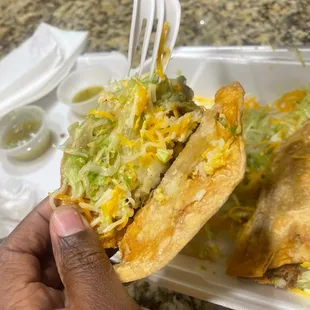 a hand holding a fork over a plate of food