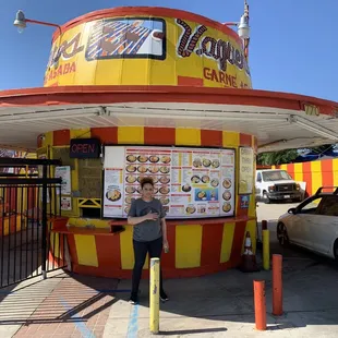 a man standing in front of a restaurant