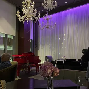 a living room with a chandelier and a piano
