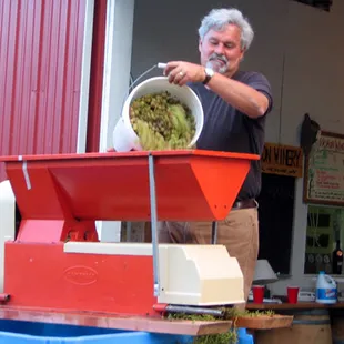 a man pouring wine into a bucket