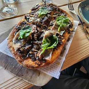 a pizza with mushrooms and lettuce