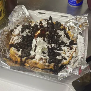 a waffle covered in chocolate and whipped cream