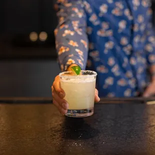 a woman holding a cocktail