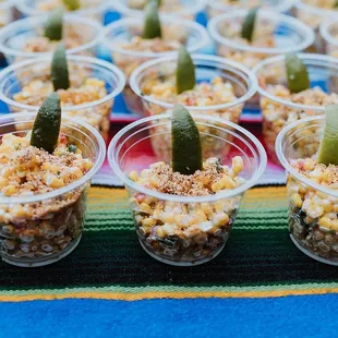 corn and pickles in plastic cups