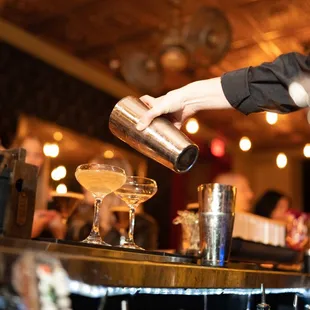 a bartender pouring a drink at a bar