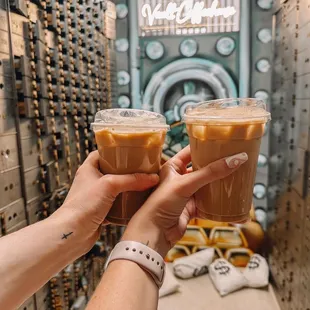 two people holding cups of coffee