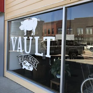 the window of a restaurant with a pig on it