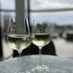 two glasses of white wine on a table