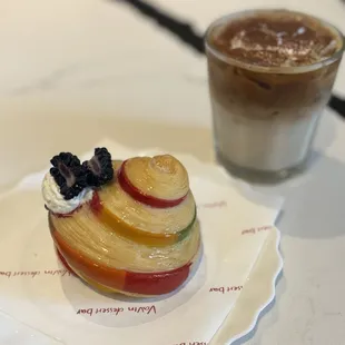 Rainbow croissant with raspberry filling and tiramisu latte
