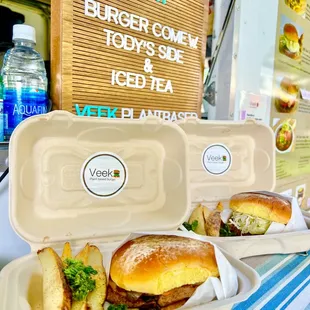 two trays of burgers and fries on a table