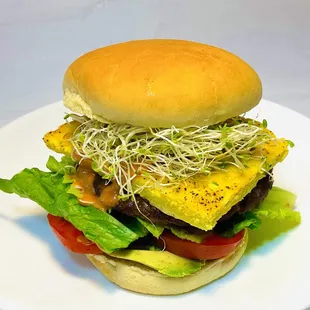 a hamburger with lettuce, tomato, and egg