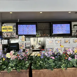 a restaurant counter with flowers in the foreground