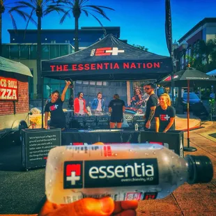 a person holding a bottle of essential pizza