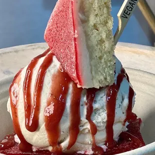 a vanilla ice cream sundae with raspberry sauce