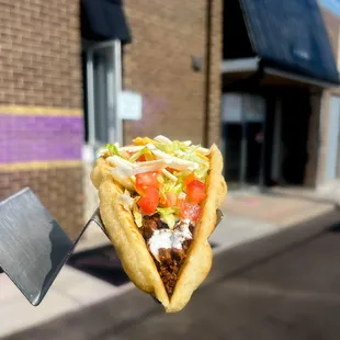 Vegan Chalupa with scratch made seitan beef, sour cream, lettuce, tomatoes and cheese