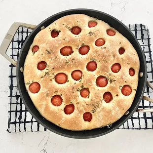 a pizza in a pan on a cooling rack