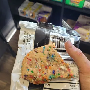 a hand holding a bag of cookies