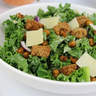 a bowl of kale salad with croutons