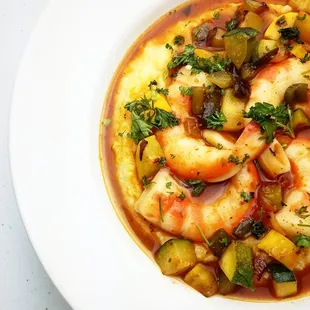 a bowl of soup with shrimp and vegetables