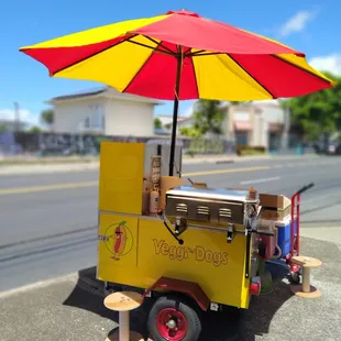 a veggie cart with an umbrella