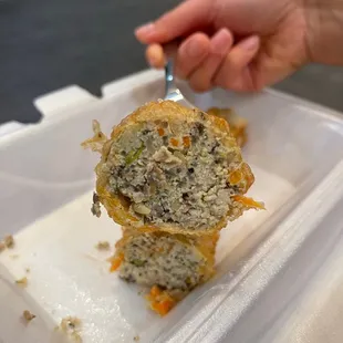 a person holding a fork in a container