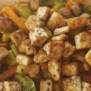 Stir fried tofu with serrano dressing, carrots, brussel sprouts, zucchini, sweet potatoes, spinach, and rice noodles underneath.