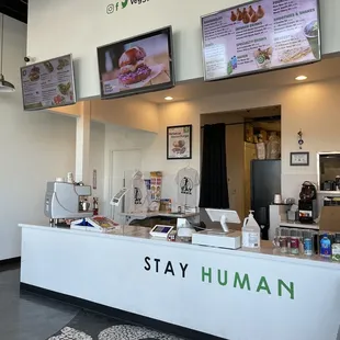 a restaurant counter with tvs on the wall