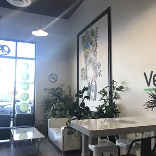 Dining area with plants and a big portrait