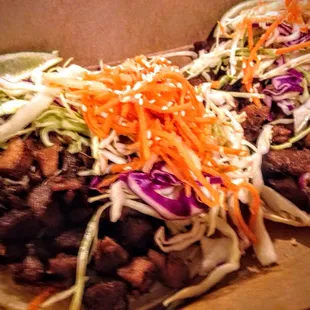 two tacos with meat and vegetables