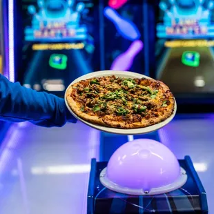 a person holding a plate of pizza