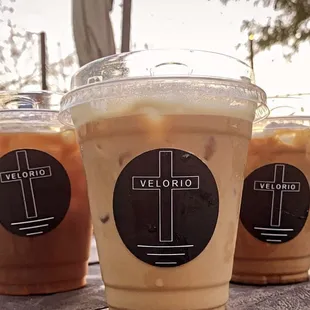 three cups of iced coffee on a table