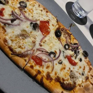 a pizza with onions, olives, and cheese
