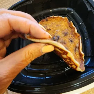 a hand holding a piece of bread