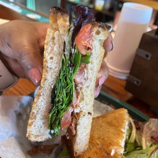 a person holding a sandwich in their hand