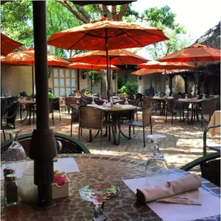 an outdoor dining area with tables and umbrellas