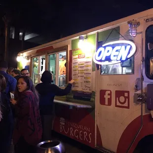 a line of people waiting in line at a food truck