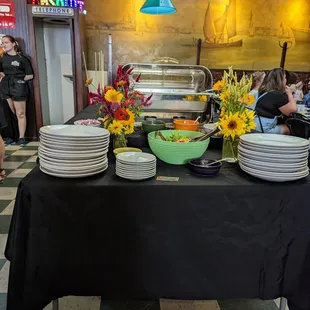 a buffet table with plates and bowls of food